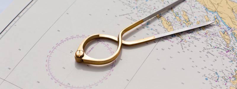 Pair of compasses for navigation on a sea map